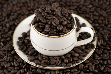 Coffee cup with roasted beans on coffee beans background