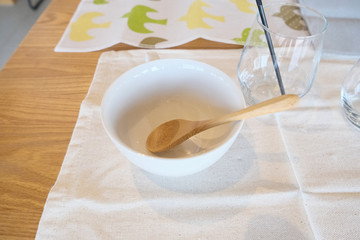 中身のないスープカップと木のスプーン