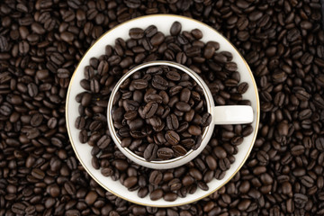 Top view of coffee cup with roasted beans on coffee beans background