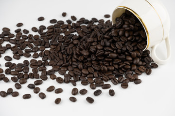 coffee cup with roasted beans spread on white background