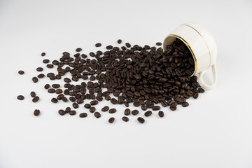 coffee cup with roasted beans spread on white background