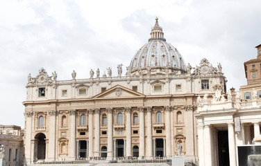 A group of Saint Statues on St. Peter's Basilica with dome and dramatic sky in Vatican City, Rome, Italy