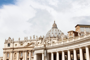 Naklejka premium A group of Saint Statues on the colonnades of St Peter's Square with dome in Vatican City, Rome, Italy