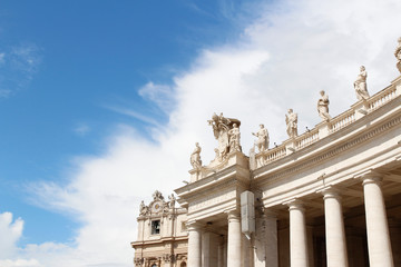 A group of Saint Statues on the colonnades of St Peter's Square with blue sky and clouds in Vatican City, Rome, Italy