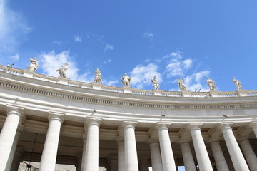 A group of Saint Statues on the colonnades of St Peter's Square with blue sky and clouds in Vatican City, Rome, Italy