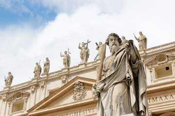 Obraz premium Statue of St. Paul with sword in front of St Peter's Basilica with blue sky and clouds in Vatican City, Rome, Italy