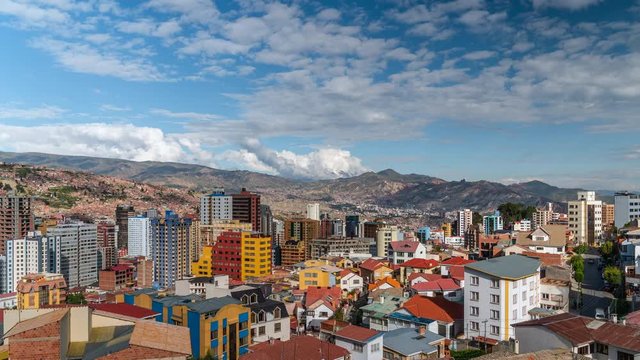 La Paz, Bolivia, zoom in time lapse view of cityscape showing residential buildings with Andes mountains in the background. 