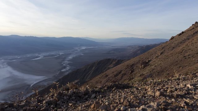 A wide timelapse of sunset looking north over a hazy Death Valley as seen from high up in Dante's View.