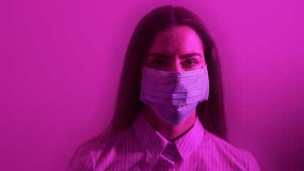 Portrait of girl that wearing protective surgical mask on face in neon lights. Fashion luxury shot, epidemic disease covid-19 virus, patient in mask isolated in dark background