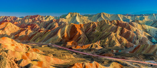 Panorama scenery of Rainbow mountain and blue sky background in sunset. Zhangye Danxia National Geopark, Gansu, China. Colorful landscape, rainbow hills, unusual colored rocks, sandstone erosion