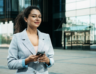 young business woman uses a mobile phone in front of a modern business center