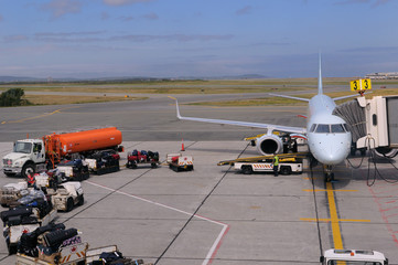 Baggage handlers loading a jet airplane at St. John`s International Airport Newfoundland