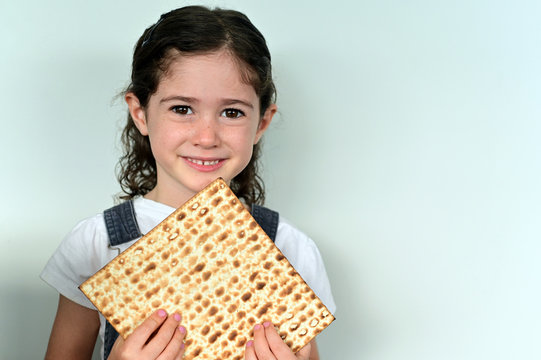 Cute Jewish girl holding Matzo bread on Passover Jewish holiday