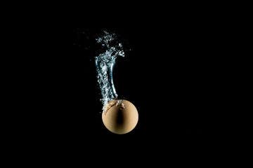 egg drop into water splash isolated with black background