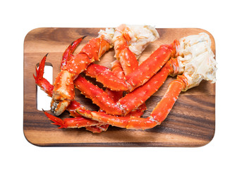Cooked Organic Alaskan King Crab Legs with Butter and lemons, Alaskan King Crab on wood plate in white background.
