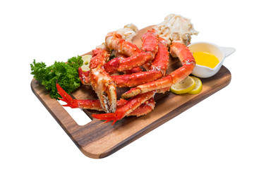 Cooked Organic Alaskan King Crab Legs with Butter and lemons, Alaskan King Crab on wood plate in white background.