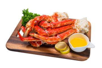 Cooked Organic Alaskan King Crab Legs with Butter and lemons, Alaskan King Crab on wood plate in white background.