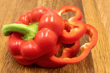 Chopped bell pepper, red capsicum on wooden board.
