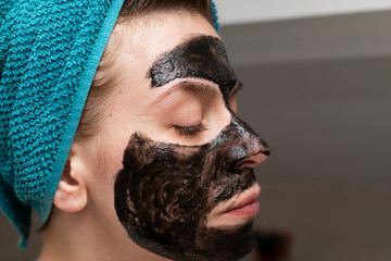Woman with black charcoal face mask