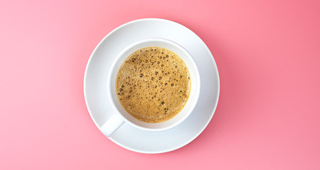 Hot coffee into a coffee white cup on pink background, Top view Food concept..