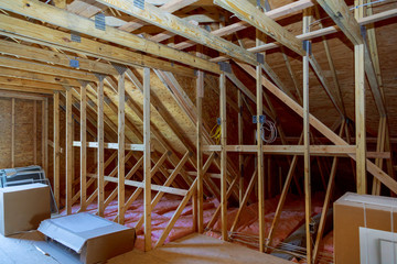 Foam plastic insulation installed in the sloping attic of new frame house.