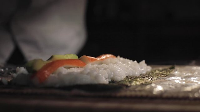 A chef Vegan Sushi roll preparation, with avocado and surimi