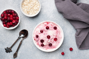 Cottage cheese dessert of yogurt jam and cranberries on a plate. grey concrete table. Concept healthy useful Breakfast. Copy space.