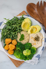 Vegan lunch bowl with quinoa, hummus, chickpeas, avocado, vegetables