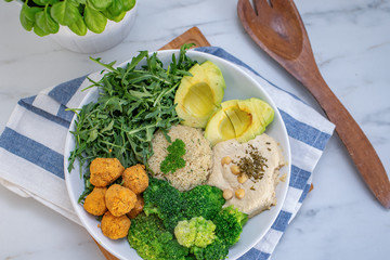 Vegan lunch bowl with quinoa, hummus, chickpeas, avocado, vegetables