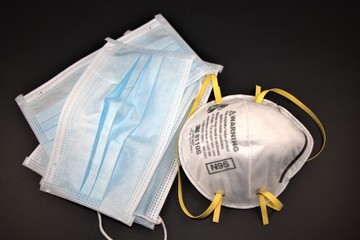 N95 respirator and surgical gloves on black background. Use as PPE or Personal Protective Equipment  for healthcare workers.