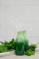 green smoothie with greens and cucumber on a white background