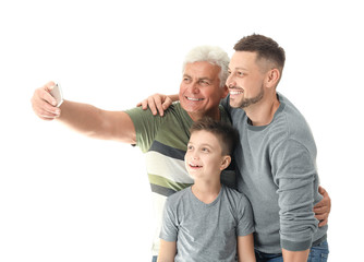 Fototapeta na wymiar Man with his father and son taking selfie on white background