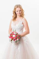 Fototapeta premium Portrait of romantic young bride in white lace wedding dress with fantasy makeup and wavy blonde hair with wedding bouquet in her hands getting ready in bride's morning. Fine art wedding.