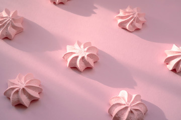 Tasty fresh and airy meringue dessert on a pink delicate background with tight shadows..