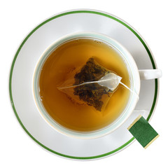 Cup with a bag of black tea top view isolated