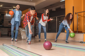 Friends playing bowling in club