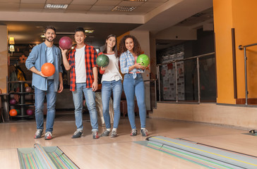 Friends playing bowling in club