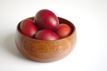 Closeup of Easter eggs in wooden bowl on white background