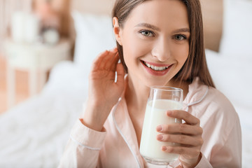 Young woman drinking milk in bedroom