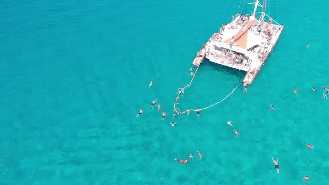 Catamaran party with a lot of people in the ocean drone shot fast