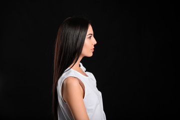 Fototapeta premium Young woman with beautiful healthy hair on dark background