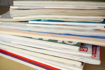a stack of glossy magazines is on the table