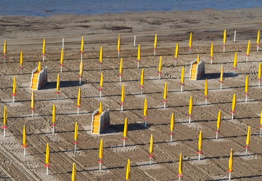 Aerial view of an empty italian beach, with closed umbrellas and folded sunbeds. Possible scenery next summer du to coronavirus epidemic