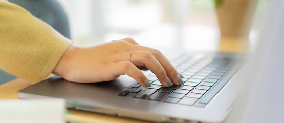 close up employee woman hand typing on keyboard laptop to search optimizations on website  for work from home and quarantine time concept