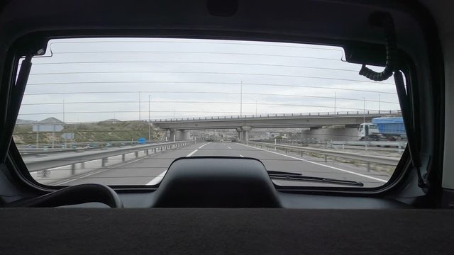 Coche por autovia pasando por debajo de un puente filmando hacia atr&aacute;s sin coches