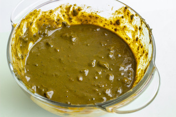 Henna for hair, diluted in a deep dish, on a light background