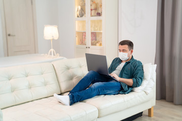 freelancer in medical mask working on couch