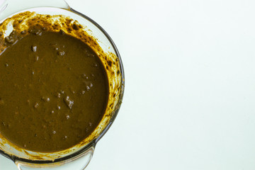 Henna for hair, diluted in a deep dish, on a light background