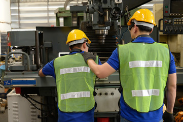 Two Male asian inspector, engineer consoling in the production line process in factory
