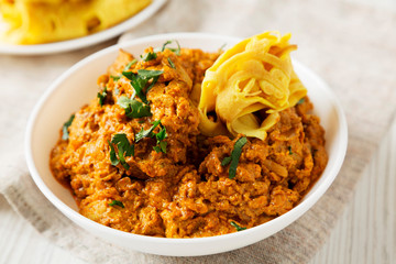 Homemade Chicken Tikka Masala in a white bowl, low angle view. Close-up.